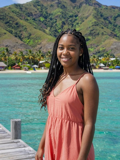 Vanessa, 23, Haitian woman from Jérémie with braided hair on wooden dock over turquoise water - Latin 312 verified profile