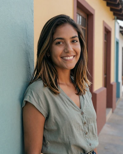 Latina woman in casual green top smiling warmly against a colorful wall representing authentic Latin dating experience