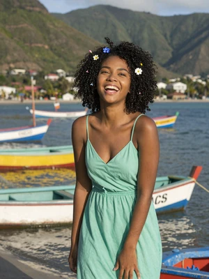 Deshana, 23, Vincentian single from Georgetown laughing near colorful waterfront with fishing boats - verified dating profile