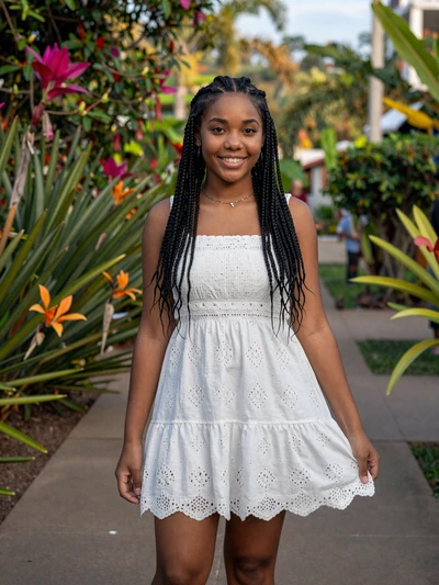 Destiny, 24, Belizean woman from Belmopan with braided hair in white summer dress among tropical flowers - Latin 312 verified profile